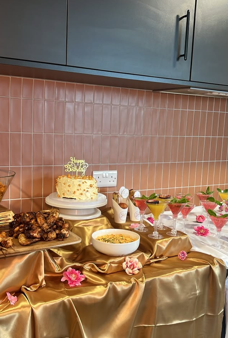 Event table styled by The Juls Cuisine with grilled chicken platter, cake and cocktails